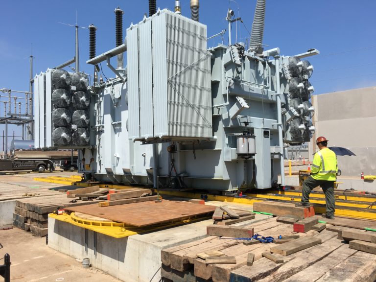 Hydra-Slide skidding system and hydraulically powered turntable are both used for this transformer slide and rotation. A Reynolds Transfer crew member watches the move closely.