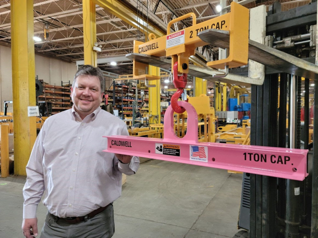 The concept was developed by Doug Stitt, president and CEO, The Caldwell Group, pictured with a pink Model 20 low headroom lifting beam. image