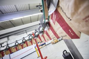 The PATHFINDER transfers bags from HAVER & BOECKER’s RADIMAT — a bag separation and feeding device — to the ROTO-PACKER automatic packing machine, achieving a fully automated packing line even in space-constrained plants image
